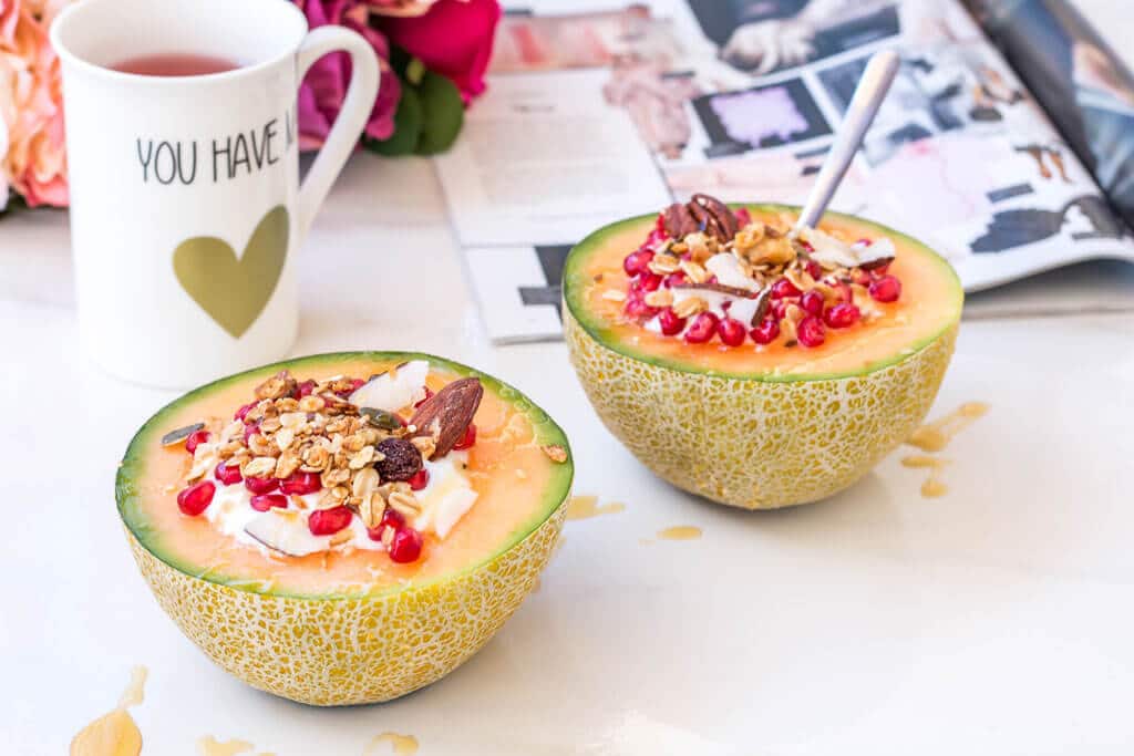 Healthy & super quick cantaloupe muesli breakfast bowls filled with low fat yogurt, homemade granola, pomegranate and a drizzle of honey. This all in one, easy to make breakfast is all you need in order to start the day on the right foot! Click through for the full recipe @ hedonistit.com