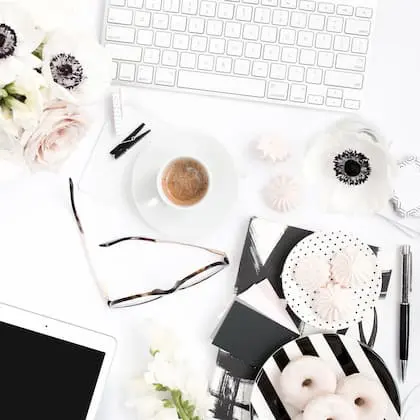 Desk flatlay with keyboard, coffee and flowers