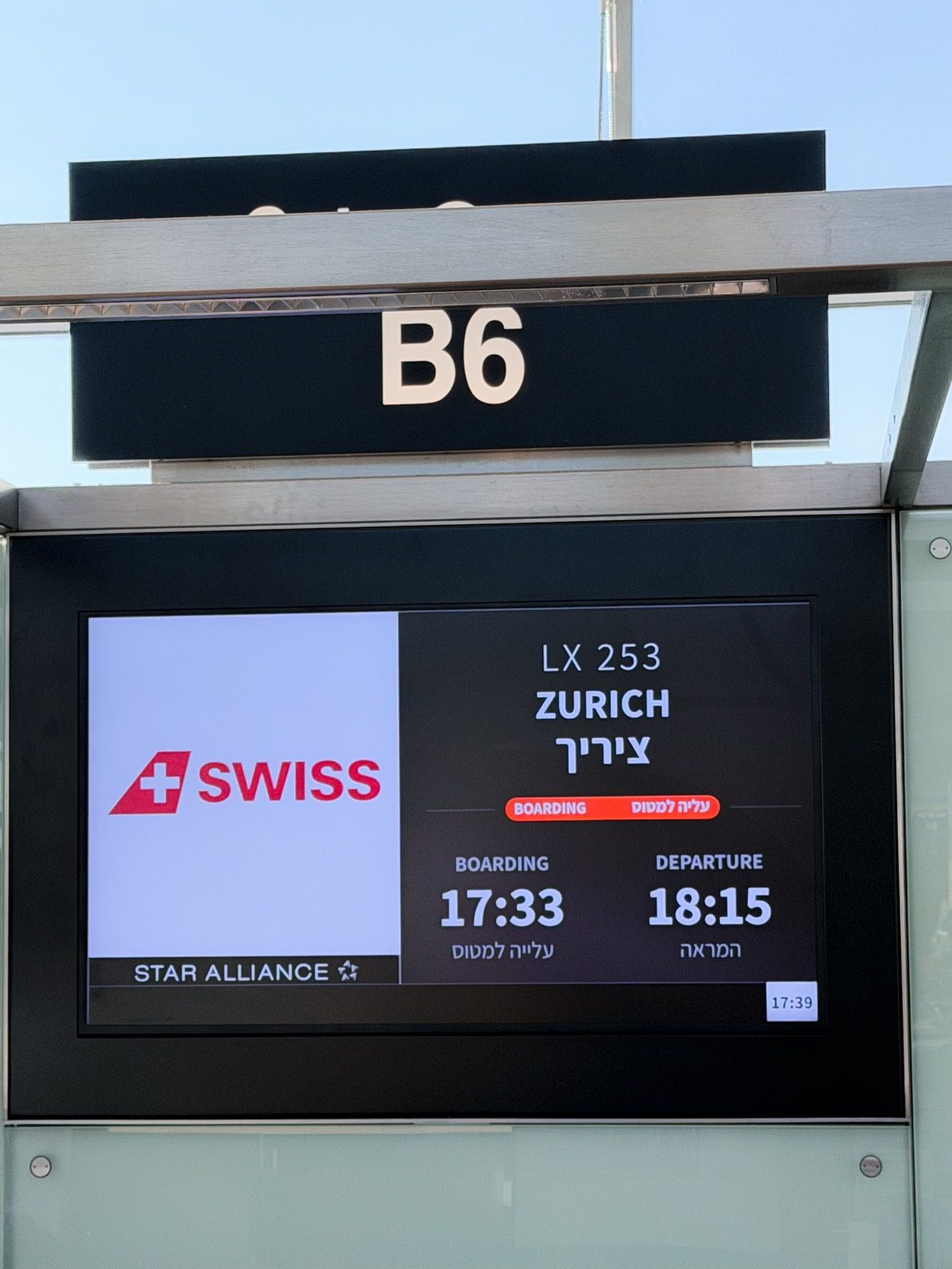 לוח הטיסה בשער העלייה למטוס, טיסת סוויס לציריך בדרך לסמינר של ג׳ו דיספנזה